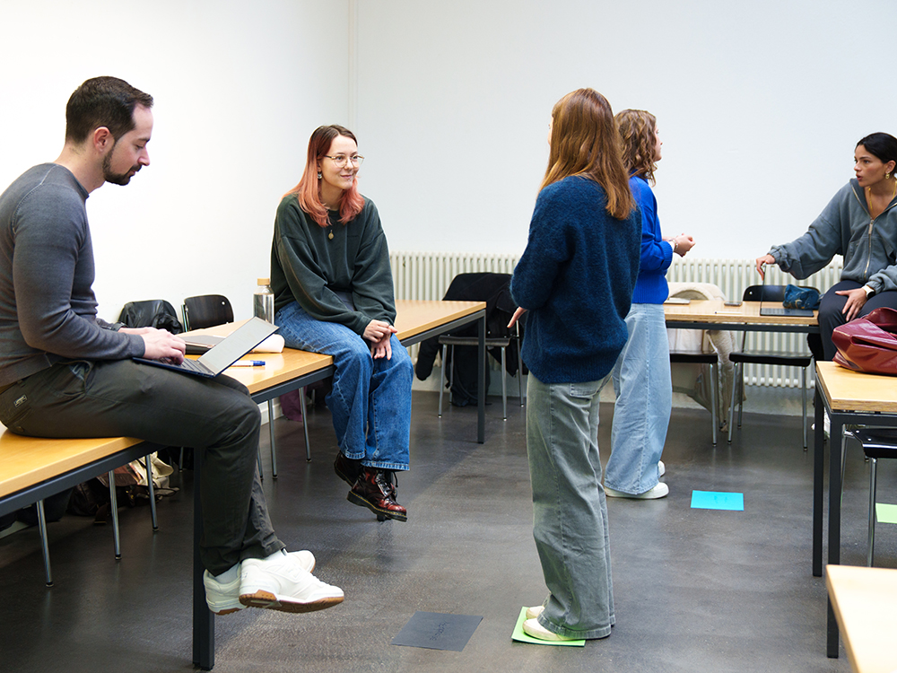 Studierende führen in einem Seminarraum praktische Übungen in kleinen Gruppen durch, um sich auf Coaching-Rollenspiele vorzubereiten. Studierende führen in einem Seminarraum praktische Übungen in kleinen Gruppen durch, um sich auf Coaching-Rollenspiele vorzubereiten.