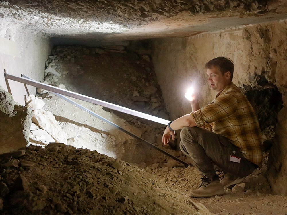 Archaeologist Lukas Richner inspecting the tunnel between the neighbouring graves Archaeologist Lukas Richner inspecting the tunnel between the neighbouring graves
