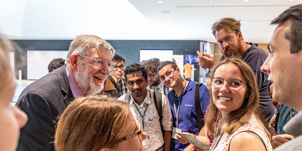 Group of participants engaged in discussion at a conference in a modern indoor setting. Group of participants engaged in discussion at a conference in a modern indoor setting.