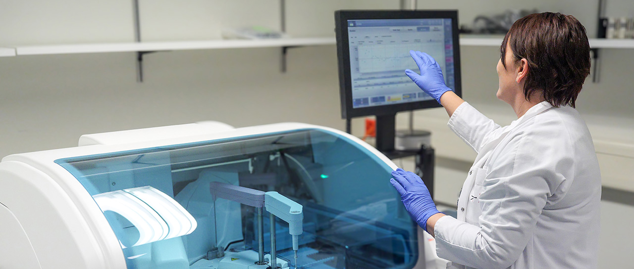 Eine Forscherin bedient ein automatisiertes System zur Analyse von Blutproben.