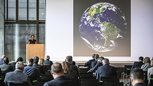 Participants of the Intergovernmental Conference of Northwestern Switzerland sit in a room and agree on a common climate charter. The earth is displayed on the projector.